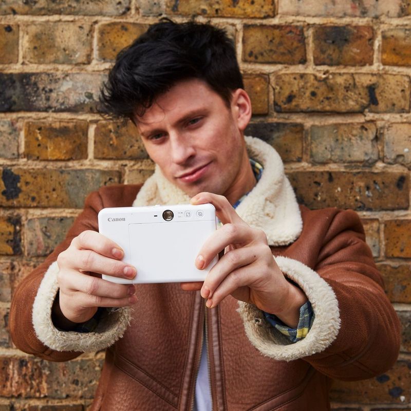Cámara impresora instantánea Canon Zoemini S, blanco perla Hombre haciéndose un selfi con la impresora