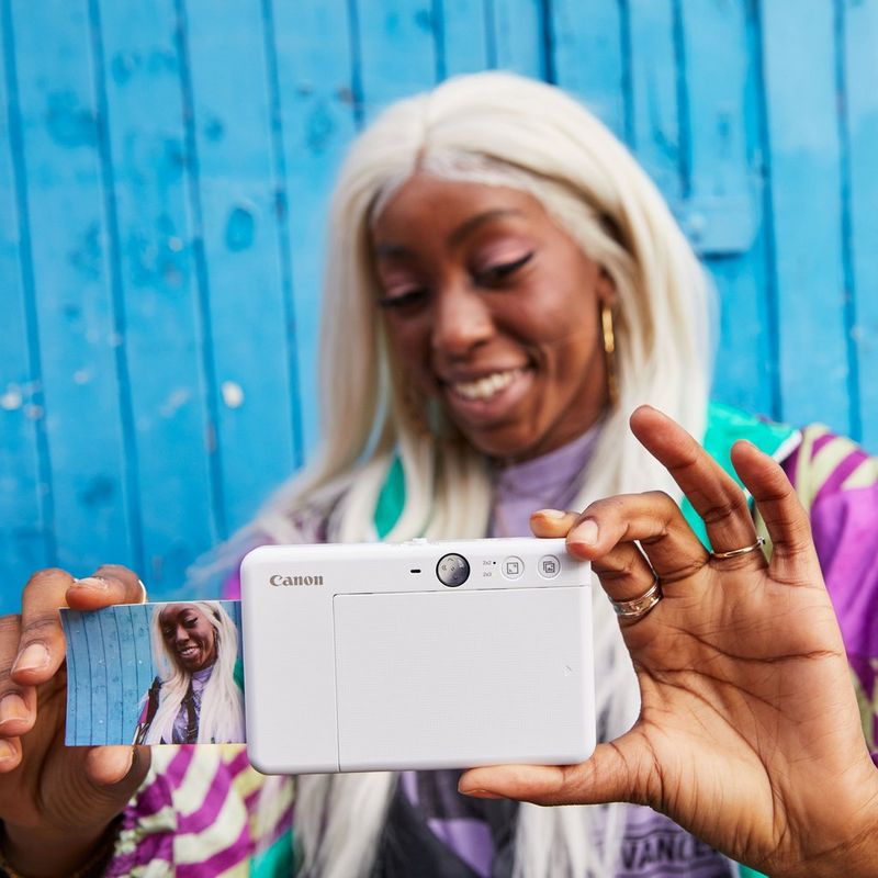 Cámara impresora instantánea Canon Zoemini S, blanco perla Mujeres haciéndose un selfi mientras la impresión sale