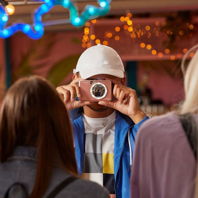 Canon Zoemini S Instant Camera Colour Photo Printer, Rose Gold Man with cap clicking photo