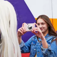 Fotocamera istantanea e stampante fotografica a colori Canon Zoemini S (oro rosa), diario e custodia Donna che scatta una foto