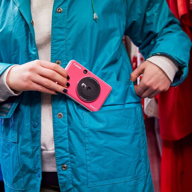 Canon Zoemini C Instant Camera Colour Photo Printer, Bubblegum Pink Women putting the printer in jacket pocket