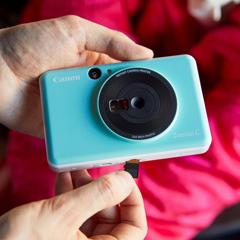 Appareil Photo Instantané Canon Zoemini C, vert menthe Mains insérant une clé USB dans l'imprimante