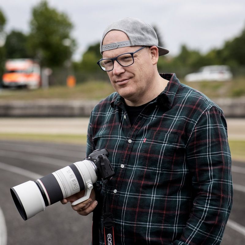 Objectif Canon RF 100-500mm F4.5-7.1L IS USM Un homme tenant un appareil photo