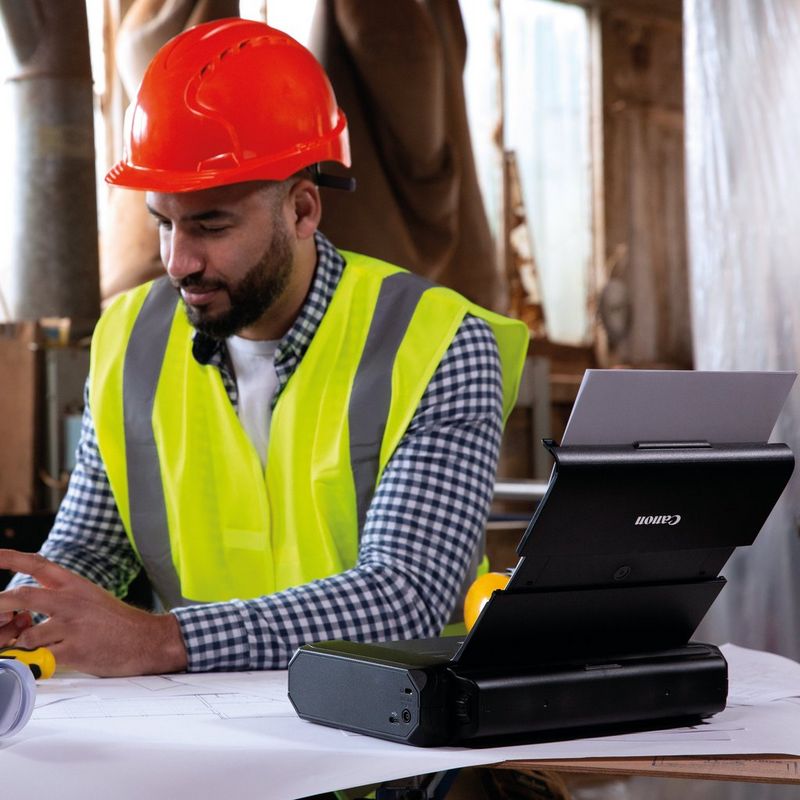 Bateria Canon LK-72 0 homem com chapéu vermelho sentado ao lado da bateria
