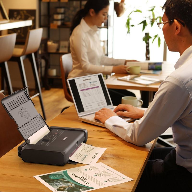 Bateria Canon LK-72 0 Homem a trabalhar num portátil ao lado da bateria