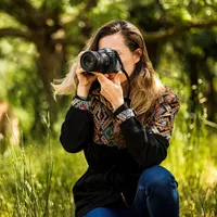 Canon RF 85mm F2 Macro IS STM Lens A Woman Holding a Camera to Her Face