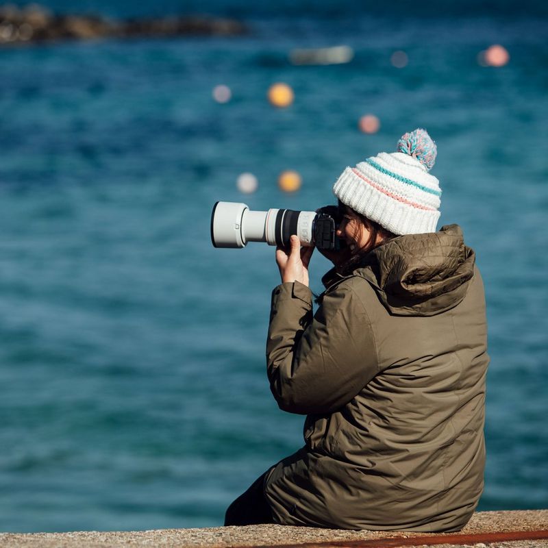 Objectif Canon RF 70-200mm F4L IS USM Une femme tenant un appareil photo près de son visage