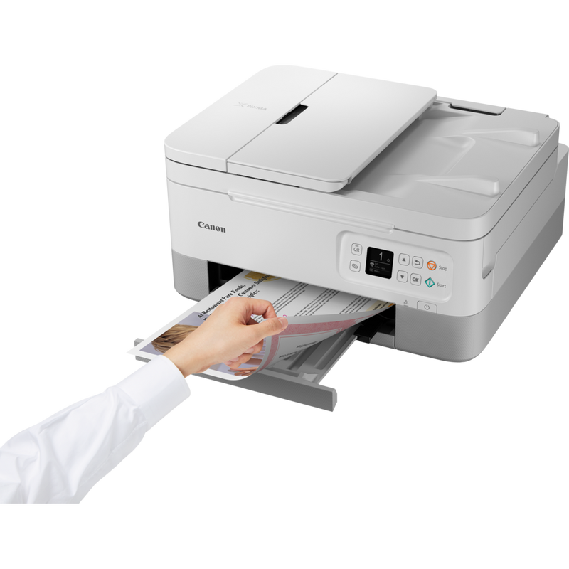 Canon PIXMA TS7451 trådløs alt-i-én-inkjet-fotoprinter, hvid Produkt Set skråt forfra med en person, der fjerner fotoet fra papirbakken