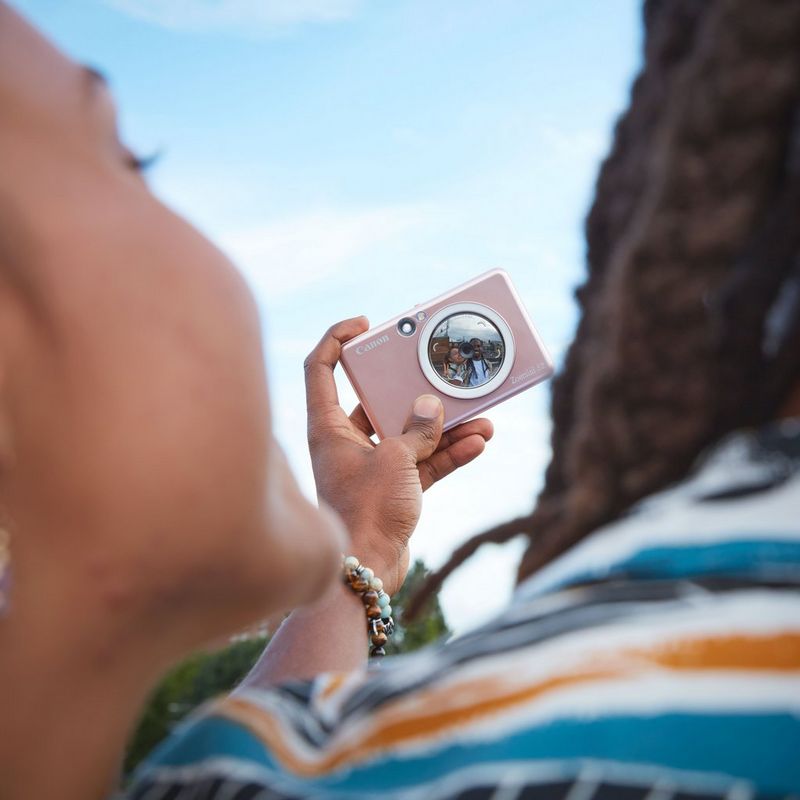 Canon Zoemini S2 Instant Camera Colour Photo Printer, Rose Gold + Diary + Pouch Couple clicking a selfie visible in the lens
