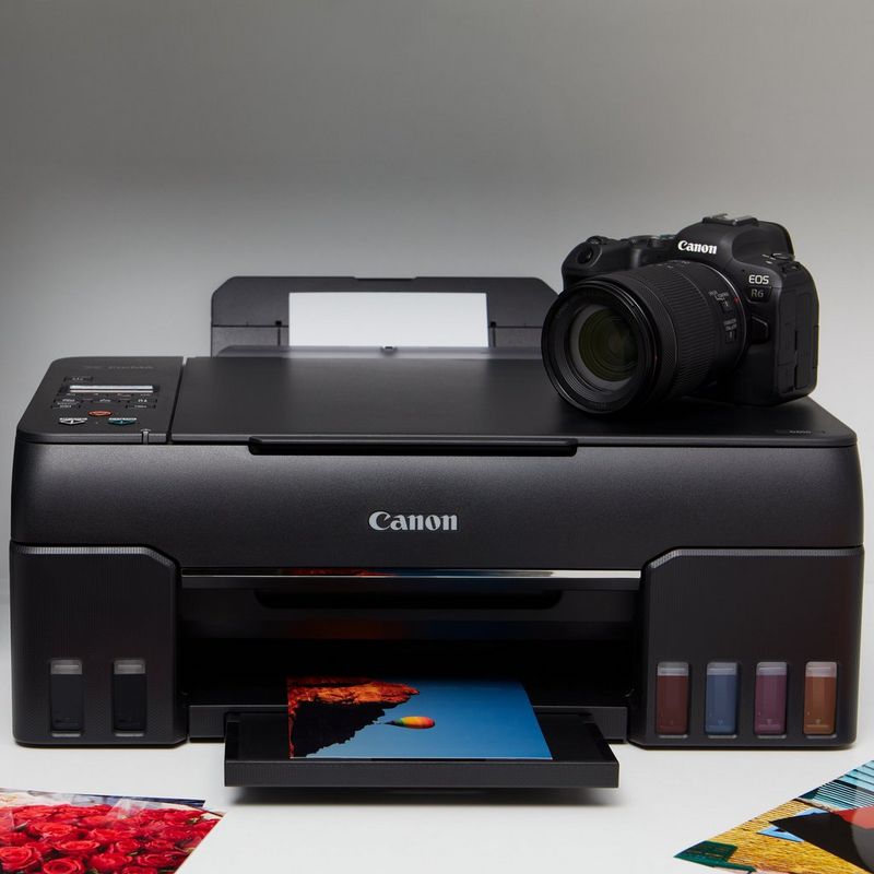 Canon PIXMA G650 Wireless 3-in-1 Refillable MegaTank Inkjet Photo Printer Front View With The Paper Tray Out And A DSLR Camera Kept on the Printer