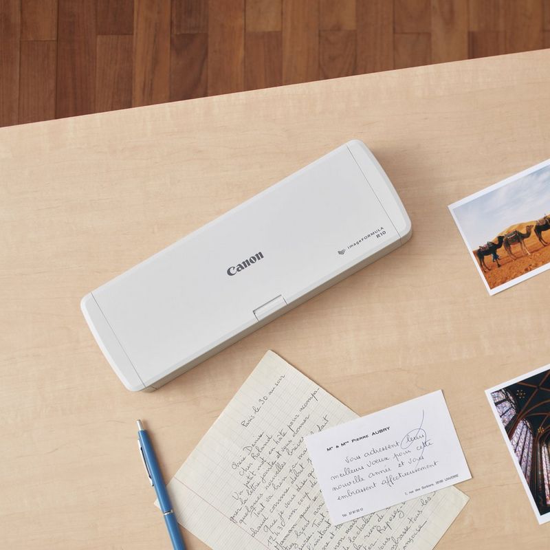 Canon imageFORMULA R10 Portable Scanner Product Scanner kept on a Desk with pen and paper