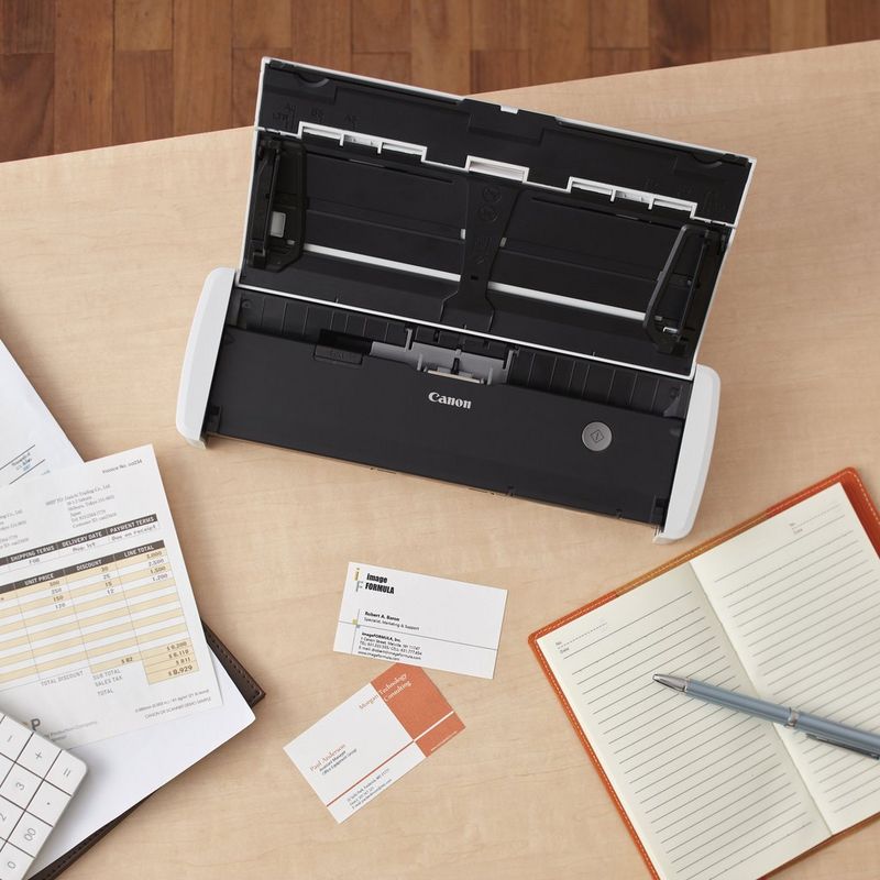 Canon imageFORMULA R10 Portable Scanner Product Scanner with panel open and kept on a desk with diary