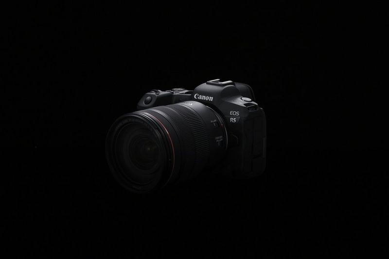 Una cámara mirrorless Full Frame EOS R5 de Canon con un objetivo colocado.