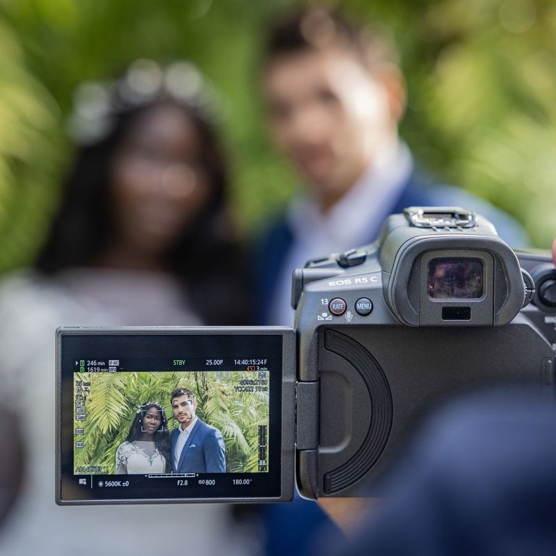 Canon EOS R5 C Cinema EOS Kameragehäuse Rückansicht mit umgeklapptem Bildschirm und Brautpaar, das fotografiert wird