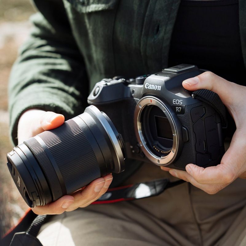 Canon EOS R7 spejlløst kamerahus + RF-S 18-150mm F3.5-6.3 IS STM-objektiv + RF-S 10-18mm F4.5-6.3 IS STM-objektiv  Person, der fastgør objektiv på kamera