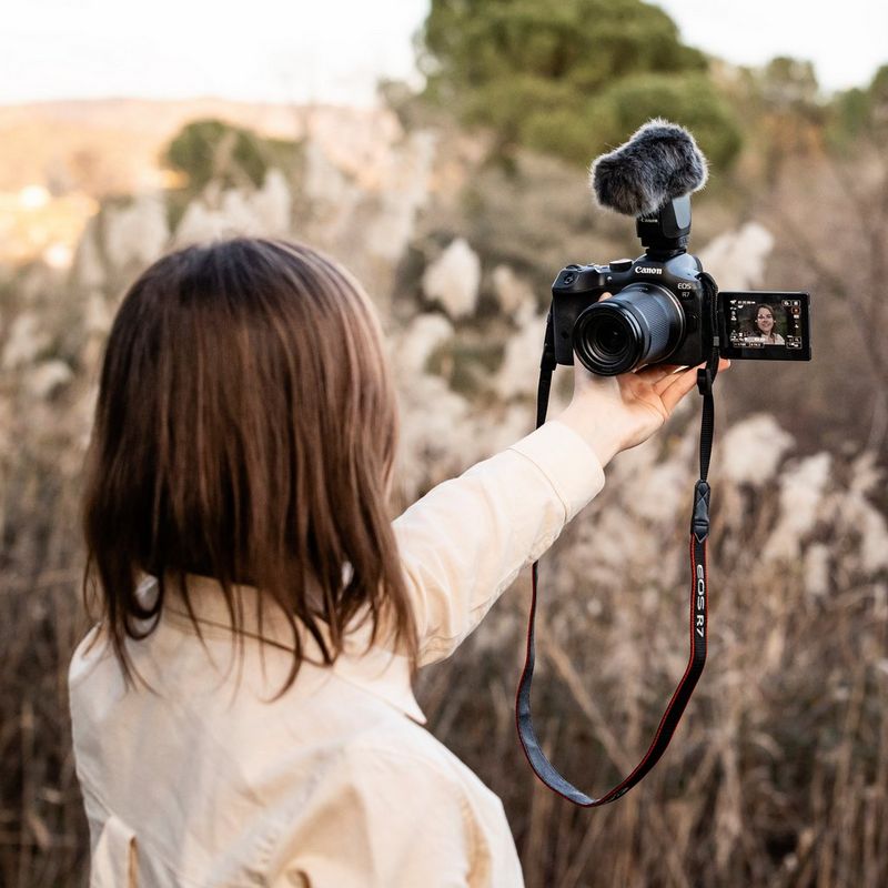 Canon EOS R7 spejlløst kamerahus + RF-S 18-150mm F3.5-6.3 IS STM-objektiv + RF-S 10-18mm F4.5-6.3 IS STM-objektiv  Kvinde, der tager selfie og ser gennem udfoldet touchscreen