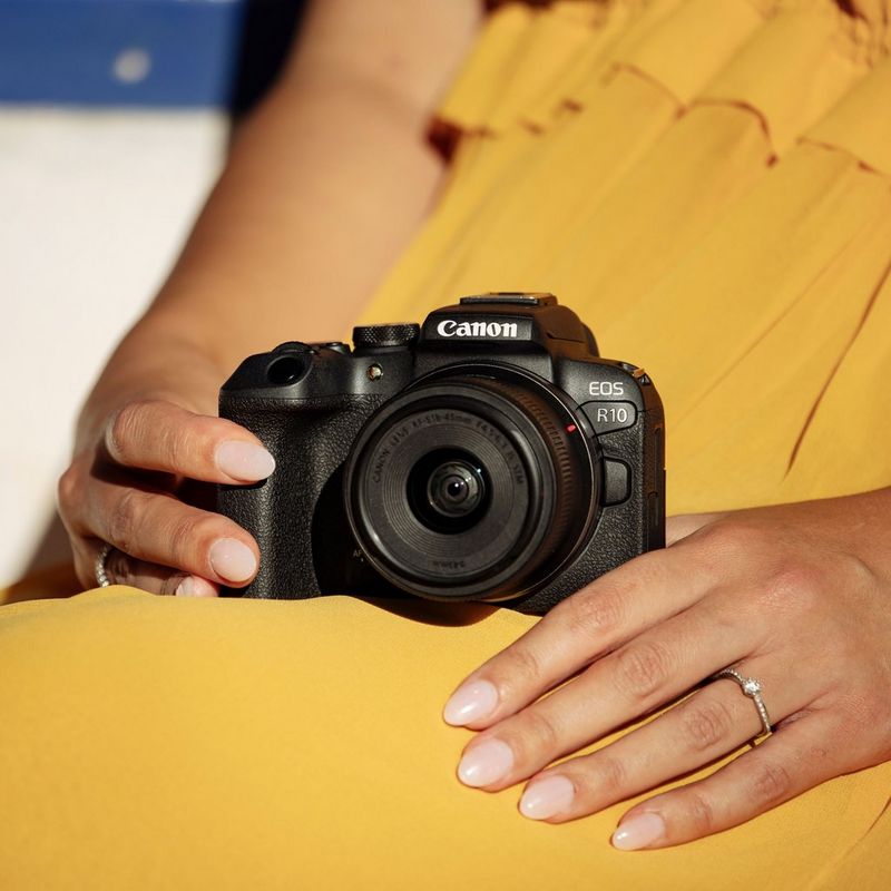 Appareil photo hybride Canon EOS R10 et objectif RF-S 18-45mm F4.5-6.3 IS STM - Appareil photo lifestyle posé sur la jambe d'une femme