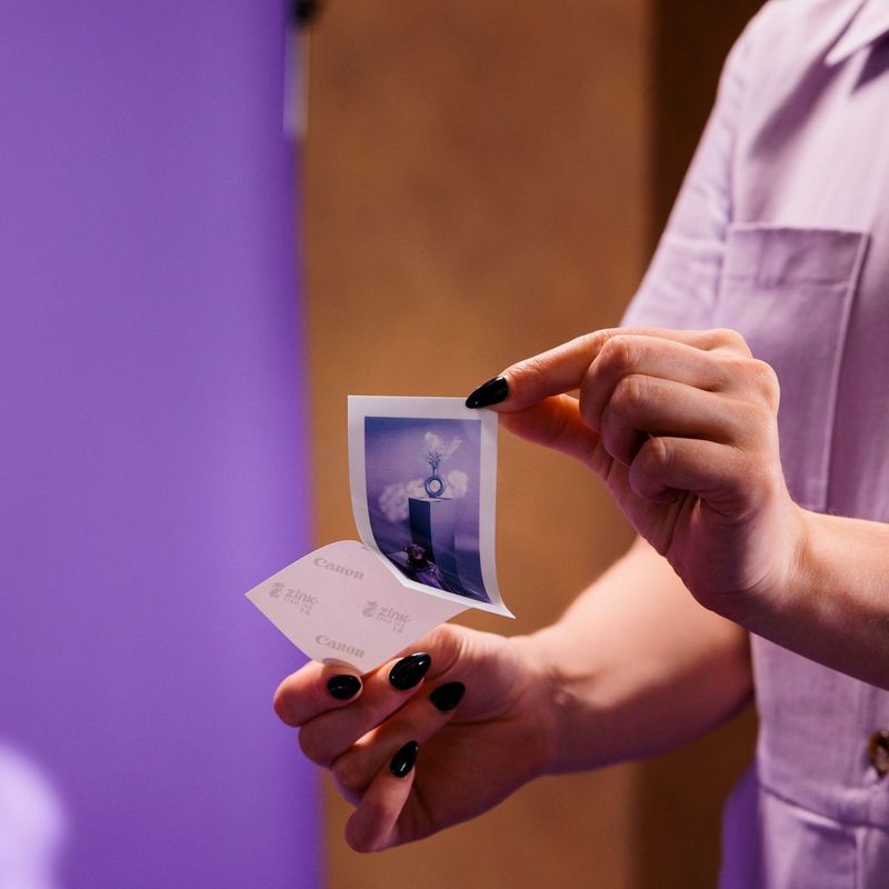 Imprimante photo couleur portable Canon Zoemini 2, rose doré Femmes retirant la partie détachable d'une photo imprimée sur du papier autocollant