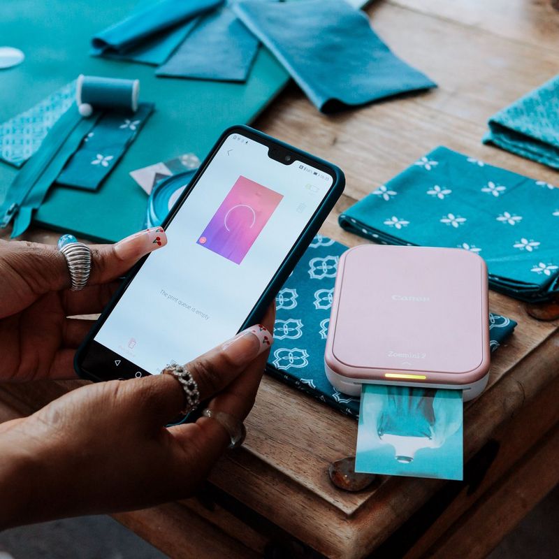 Imprimante photo couleur portable Canon Zoemini 2, rose doré + papier photo autocollant ZINK™ 5 × 7,6 cm (20 feuilles) + papier autocollant circulaire ZINK™ 3,3 cm (10 feuilles) Femmes effectuant une impression depuis un mobile