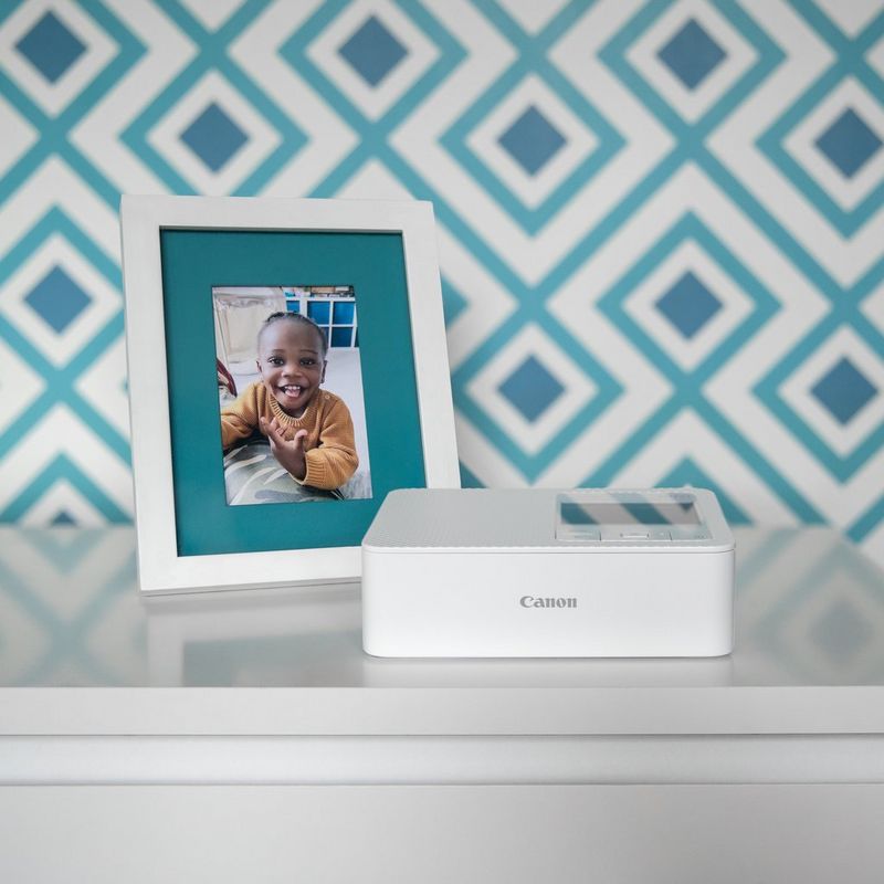 Pöydällä on tulostin ja valokuvakehys