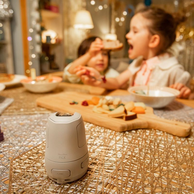 Canon PowerShot PX Compact Concept Camera Essential Kit, White Camera on a wooden table with kids playing on the bed