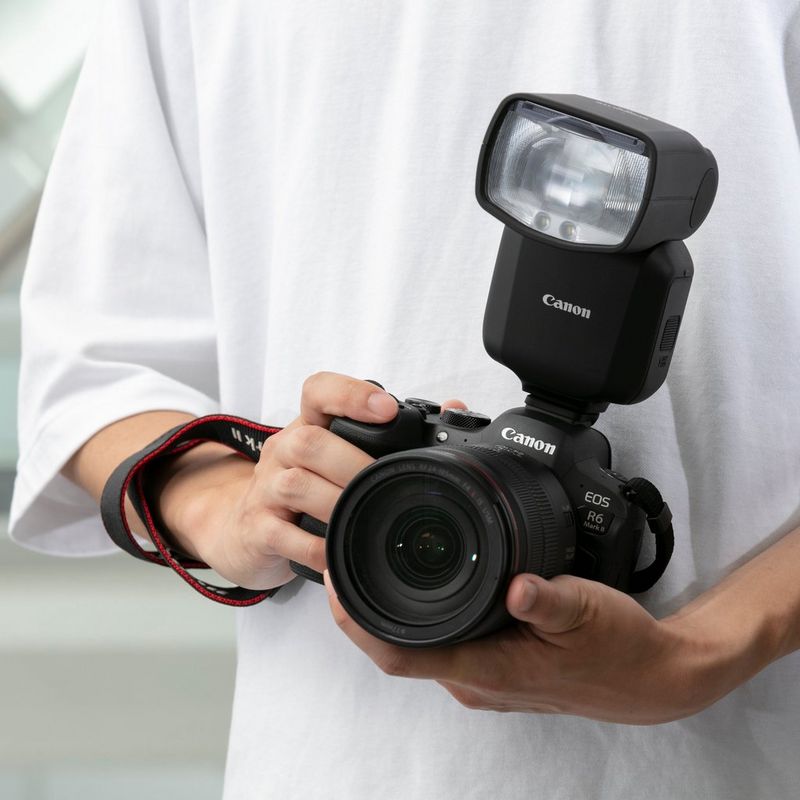 Man holding a camera with the flash attached
