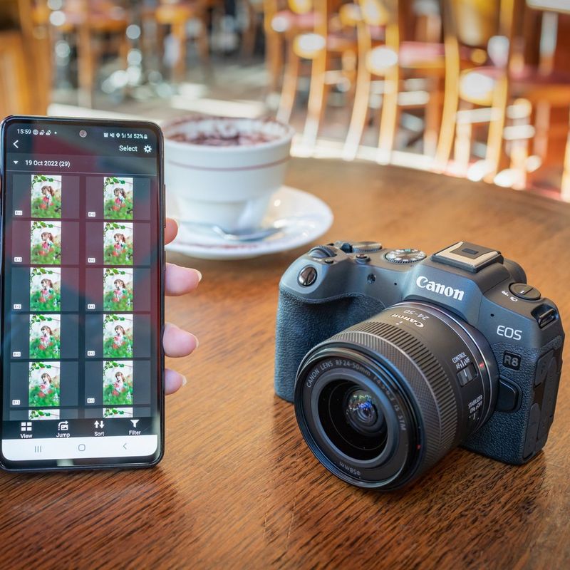 Canon EOS R8 spiegellose Kamera (Gehäuse), Schwarz + RF 85mm Macro IS STM Objektiv + RF 24-50mm IS STM Objektiv Eine Person, die Fotos auf einem Telefon betrachtet