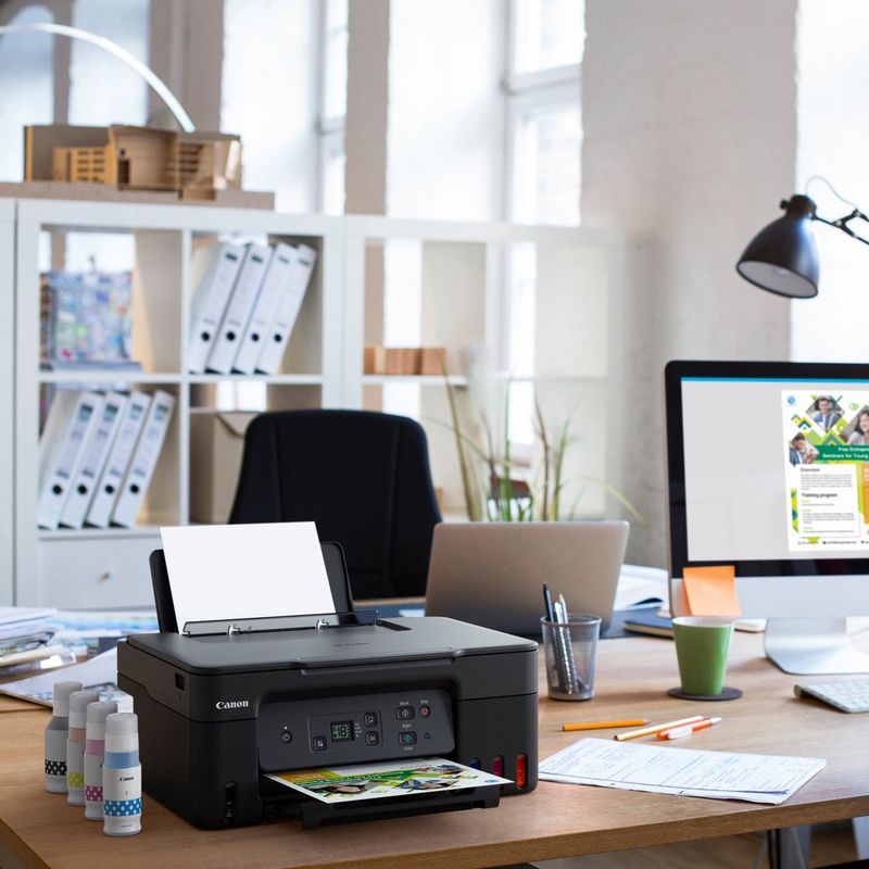 Canon PIXMA G2470 Colour 3-in-1 Refillable MegaTank Printer Product kept on a Office Desk with ink bottles