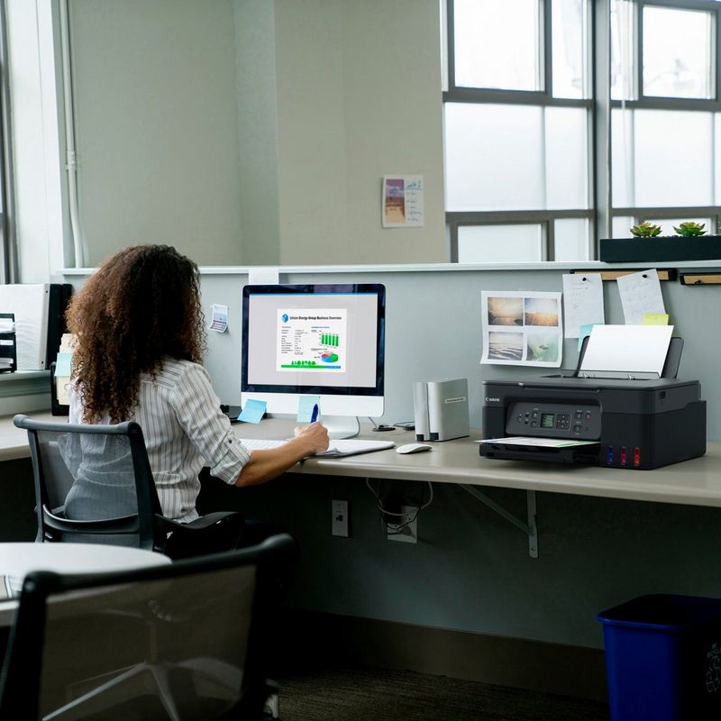 Canon PIXMA G3570 Wireless Colour 3-in-1 Refillable MegaTank Printer, Black Product kept on Office Desk with a women working on a computer