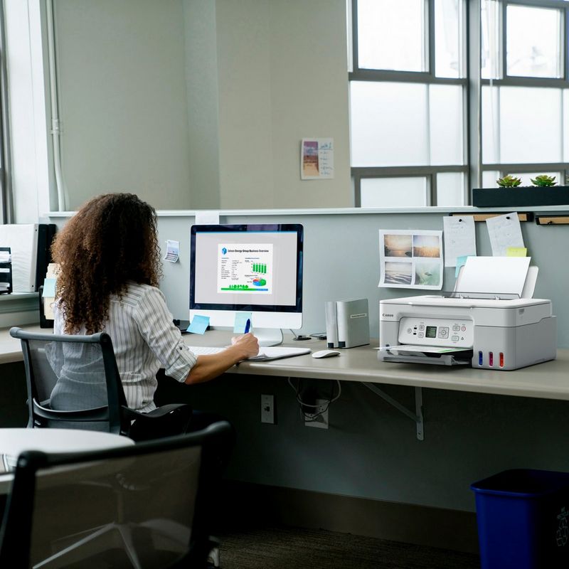 Canon PIXMA G3571 Wireless Colour 3-in-1 Refillable MegaTank Printer, White Product kept on Office Desk with a women working on a computer