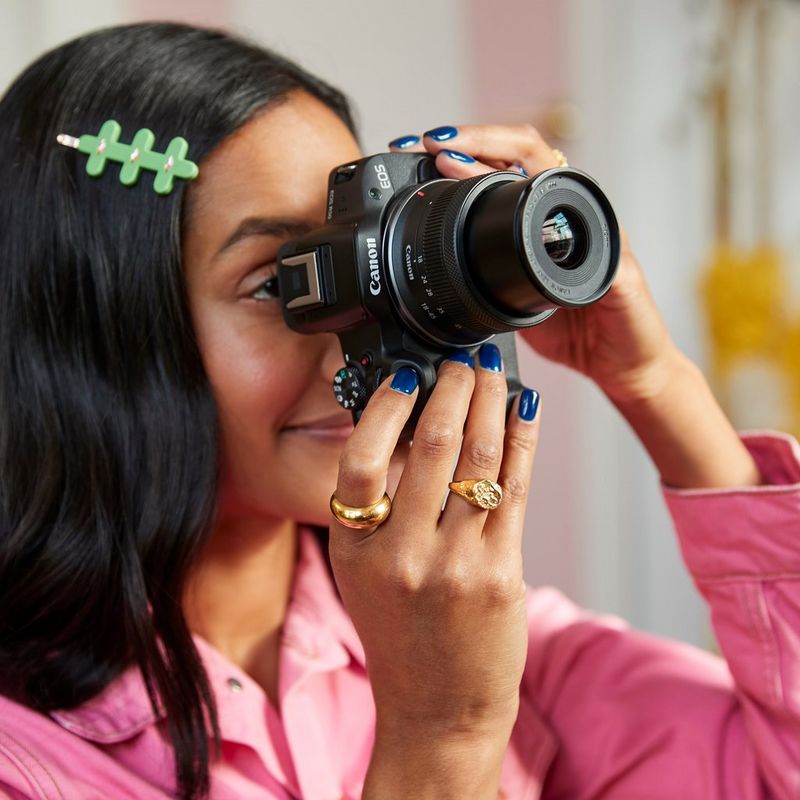 Canon EOS R50 Mirrorless Camera, Black and RF-S 18-45mm F4.5-6.3 IS STM Lens Women clicking a photo