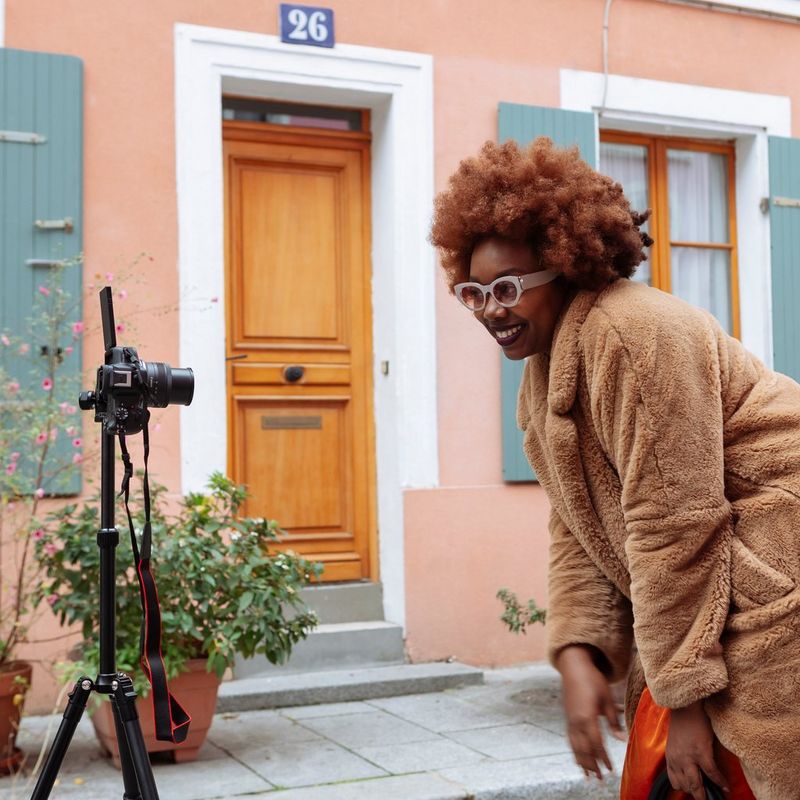 Canon EOS R50 Mirrorless Camera, Black + RF-S 18-45mm IS STM Lens + RF-S 55-210mm IS STM Lens Women posing in front of the product