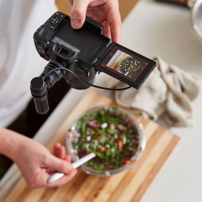 Appareil photo hybride Canon EOS R50 noir - Kit pour vlogueur Homme photographiant un plat