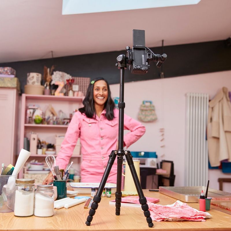 Appareil photo hybride Canon EOS R50 noir - Kit pour vlogueur Femme enregistrant des images à l'aide du produit fixé sur un trépied