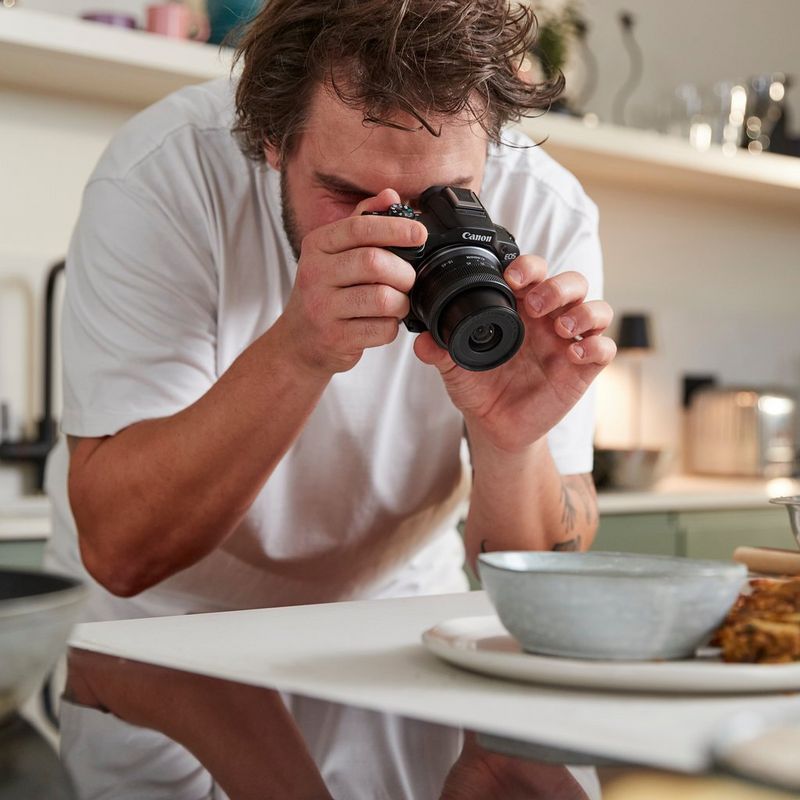 Canon EOS R50 Mirrorless Camera, Black + RF-S 18-45mm F4.5-6.3 IS STM Lens + Backpack + SD Card Man photographing a dish