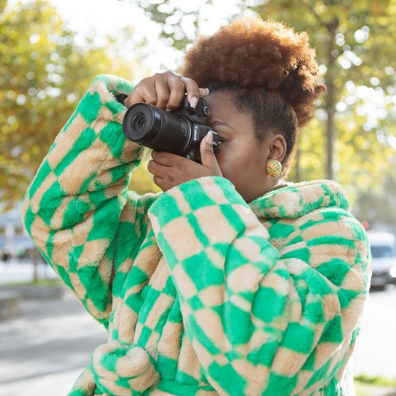 Canon RF-S 55-210mm F5-7.1 IS STM Lens Women in green jacket clicking a photograph