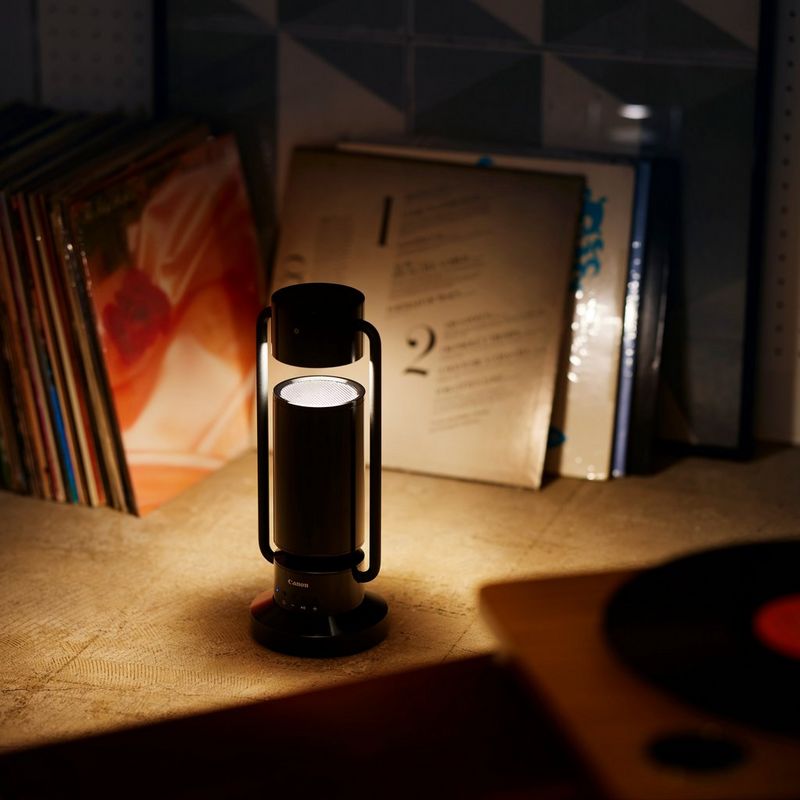 Lámpara Bluetooth inalámbrica de aluminio Canon Luz & Altavoz ML-A - negro Producto en un estante con la lámpara encendida