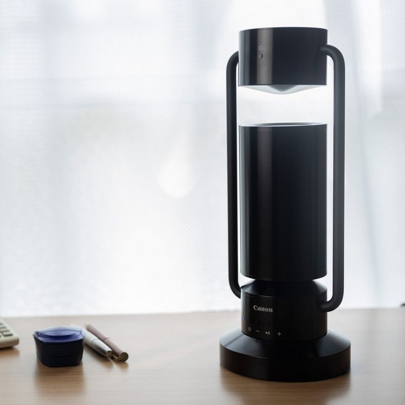 Lámpara Bluetooth inalámbrica de aluminio Canon Luz & Altavoz ML-A - negro Producto sobre una mesa de estudio