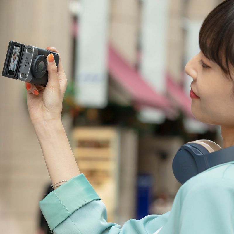 PowerShot-V10 Woman vlogging holding product sideways with screen tilted-up