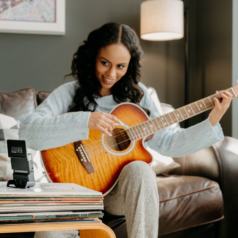 PowerShot-V10 Woman playing guitar and vlogging with product on table with screen tilted-up