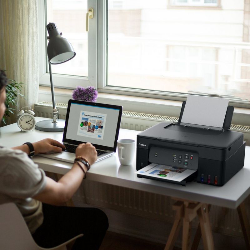 Canon PIXMA G2430 Colour 3-in-1 Refillable MegaTank Printer user printing a document using his laptop