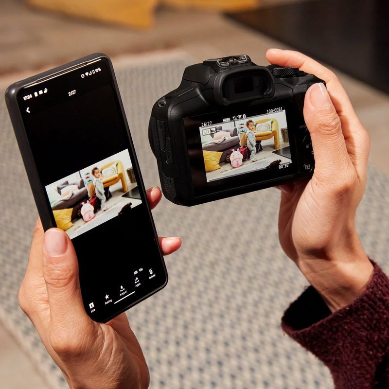 Canon EOS R100 Mirrorless Camera Woman viewing photos on product and phone