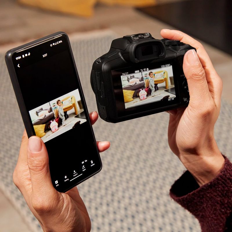 Canon EOS R100 Mirrorless Camera Woman viewing photos on product and phone