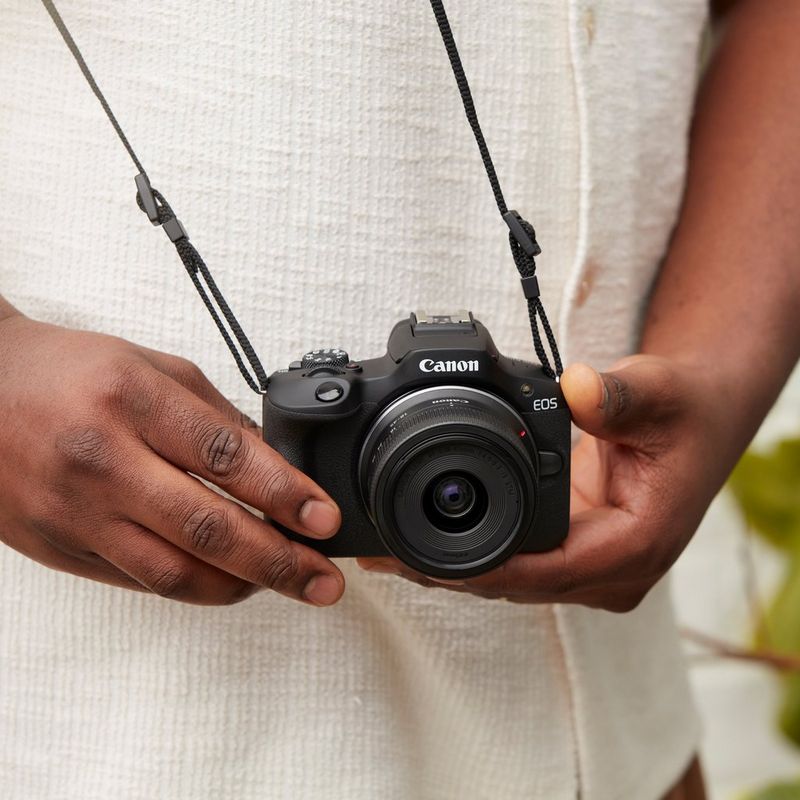 Canon EOS R100 Mirrorless Camera Product hanging on man with neck strap