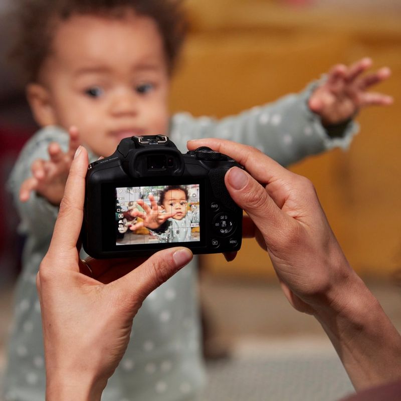 Canon EOS R100 Mirrorless Camera + RF-S 18-45mm F4.5-6.3 IS STM Lens + Backpack + SD Card Man clicking picture of a baby
