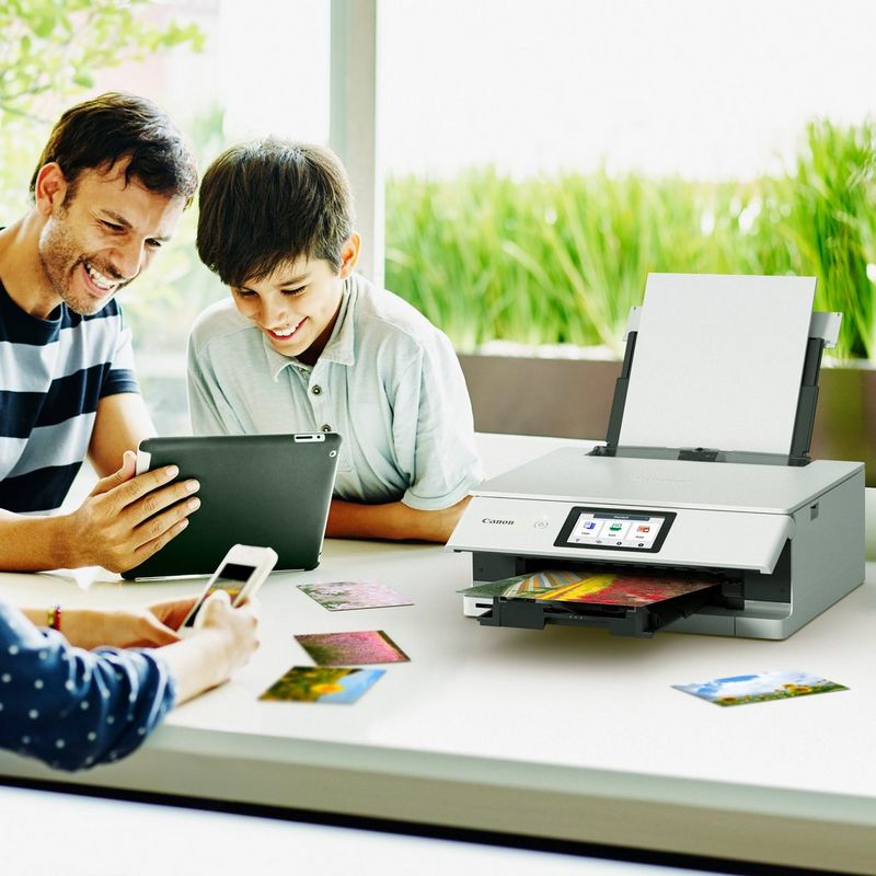 Famille qui passe du temps ensemble et imprime des photos à l'aide d'une tablette