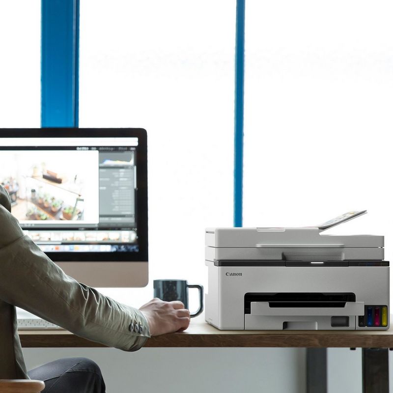 Canon MAXIFY GX2050 Wireless Colour All-in-One Refillable MegaTank Inkjet Printer Product printer kept on a work station next to a computer