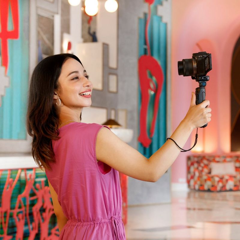 Objectif Canon RF-S 10-18mm F4.5-6.3 IS STM Une personne réalisant des vlogs avec un appareil équipé du produit et d'un support