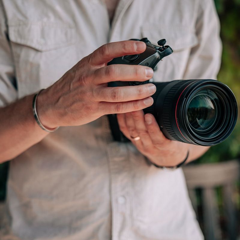 Adaptador de zoom motorizado Canon PZ-E2 Hombre acoplando el producto a un objetivo