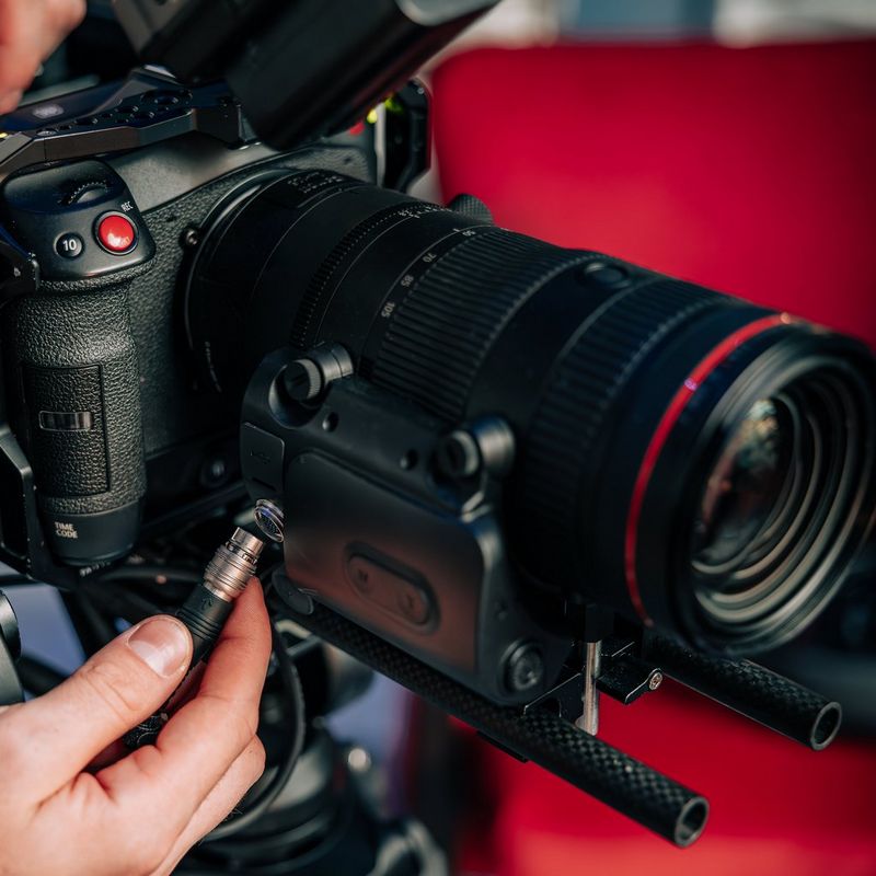 Adapter zaawansowanego zoomu Canon PZ-E2B Mężczyzna podłącza kabel do produktu